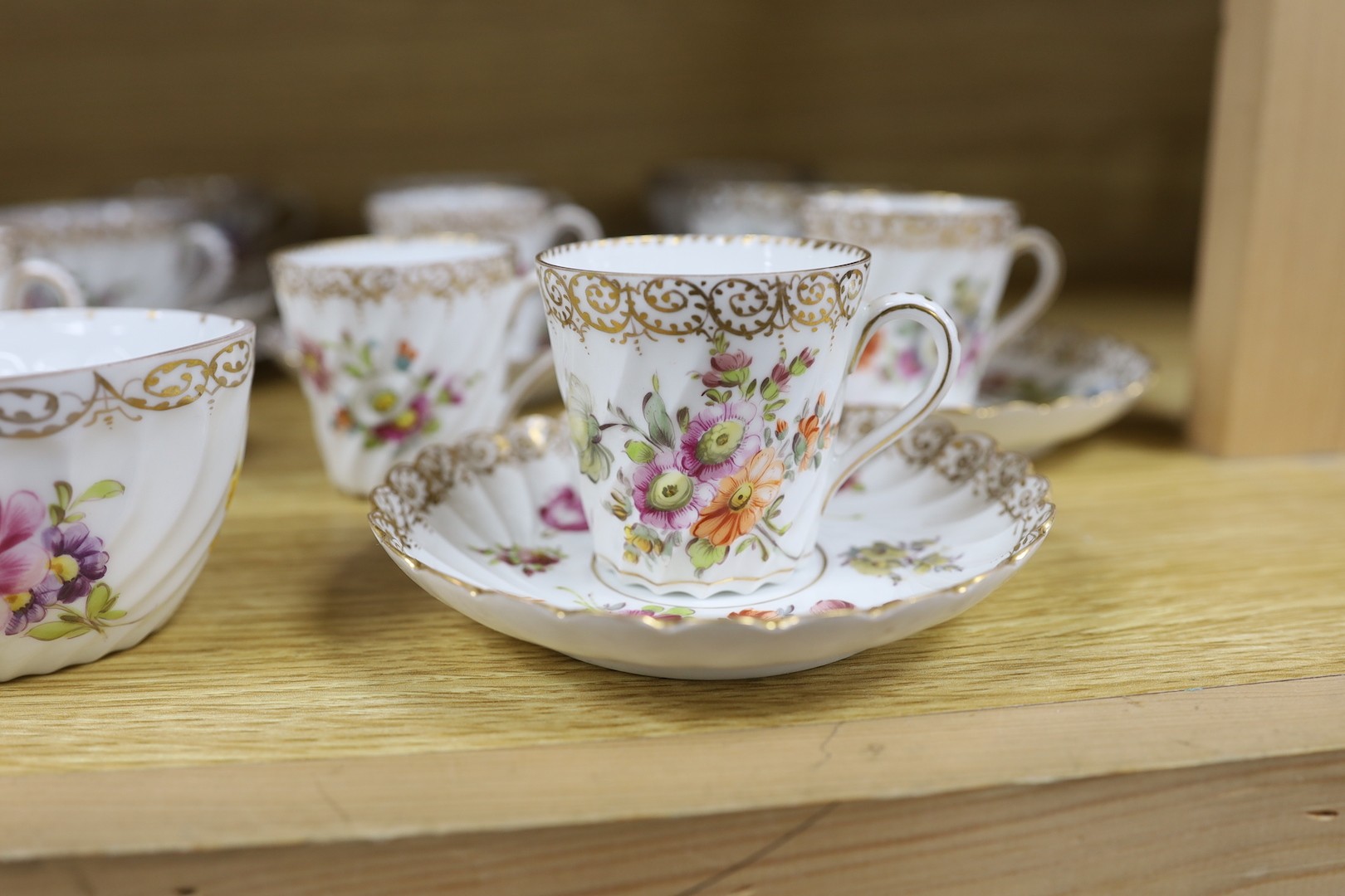 A quantity of Nymphenburg and Dresden porcelain cups and saucers